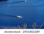 Aerial view of white paddle steamer Uri with waving Swiss flag crossing Swiss Lake Lucerne on a sunny spring day. Photo taken April 11th, 2024, Bürgenstock, Lake Lucerne, Switzerland.