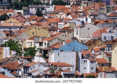 aerial view of the white and pastel-colored old buildings with red-tiled roofs in the charming, winding old town of lisbon - Powered by Shutterstock