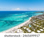 Aerial view of white sand beach with many all inclusive hotels in Punta Cana. Turquoise water, tall palm trees and straw umbrellas on the coast. Best place for summer vacations 