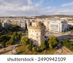 Aerial view of the White Tower in Thessaloniki, Greece, surrounded by lush greenery and the vibrant cityscape, showcasing the historical and cultural richness of this iconic landmark