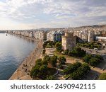 Aerial view of the White Tower in Thessaloniki, Greece, surrounded by lush greenery and the vibrant cityscape, showcasing the historical and cultural richness of this iconic landmark