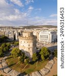 Aerial view of the White Tower in Thessaloniki, Greece, surrounded by lush greenery and the vibrant cityscape, showcasing the historical and cultural richness of this iconic landmark