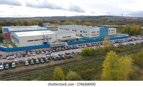 Aerial View Of White Truck With Cargo Semi Trailer Moving Near Loading Warehouse Area. Large Delivery Truck Is Moving. Aerial Shot Of Lorry On Road In Beautiful Countryside.