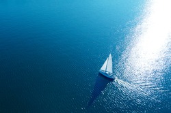 Aerial View Of A White Yacht With A Sail. Ship In The Blue Sea