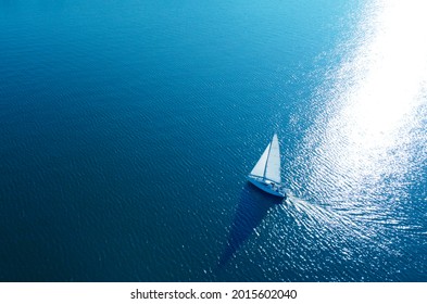 Aerial view of a white yacht with a sail. Ship in the blue sea - Shutterstock ID 2015602040