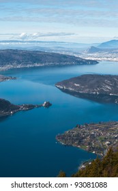 Aerial view of wide expanse of clear blue Annecy Lake from atop the French Alps mountain at Col de la Forclaz, France on a sunny, bright sky day. Vertical copy space