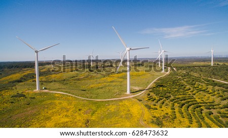 Aerial view of Wind Generating stations in green fields on a background of blue sky. Portugal.