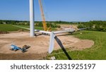 Aerial view of a wind turbine blade assembly on the ground in preparation for lifting up to the nacelle on the tower