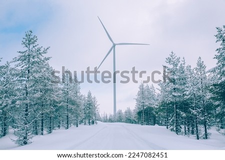 Aerial view Wind turbine in snow winter landscape in Finland, Europe. Alternative energy in winter.