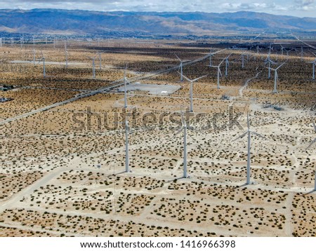 Aerial view of wind turbines generating electricity. Huge array of gigantic wind turbines spreading over the desert in Palm spring wind farm. California. USA
