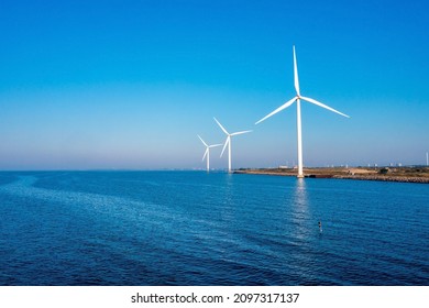 Aerial View Of The Wind Turbines. Green Ecological Power Energy Generation. Wind Farm Eco Field. Offshore And Onshore Windmill Farm Green Energy At Sea.