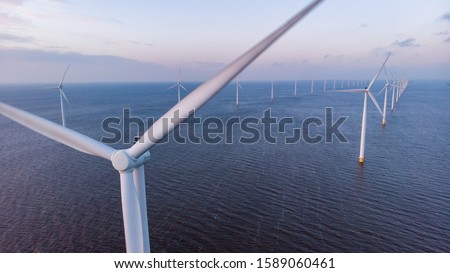 Aerial view of wind turbines at sea, North Holland, Netherlands, Beautiful sunset above the windmills 