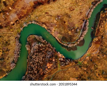 Aerial View Of Winding River And Road In Golden Colored Autumn Or Fall Forest