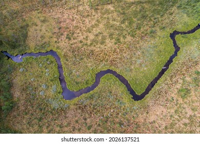 Aerial view of windling river in zig zag formation in desolate landscape environment