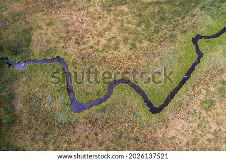 Aerial view of windling river in zig zag formation in desolate landscape environment