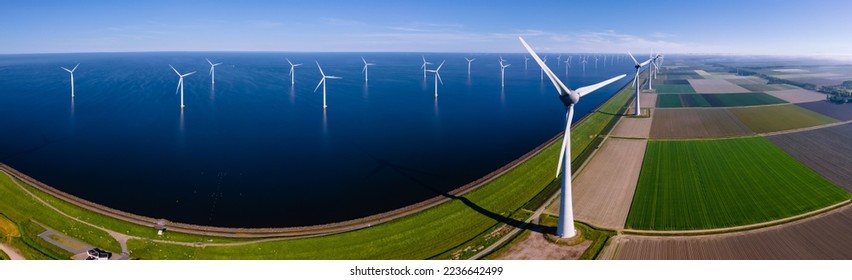 Aerial view at Windmill park with windmills turbines during winter generating electricity with a blue sky green energy concept. Wind mill with clouds - Shutterstock ID 2236642499