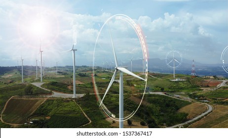 Aerial view of windmills with digitally generated holographic display tech data visualization. Wind power turbines generating clean renewable energy for sustainable development in a green ecologic way