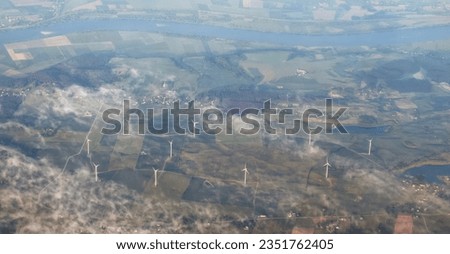 Aerial view of windmills in a green summer forest in Europe. Wind turbines for electric power with clean and Renewable Energy