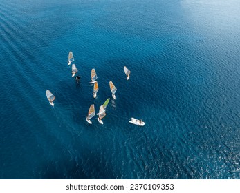 Aerial view of a windsurfing school training over turquoise sea with copy space