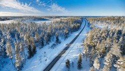 Aerial View Of Winter Road Cutting Through Scandinavian Forest In Sweden