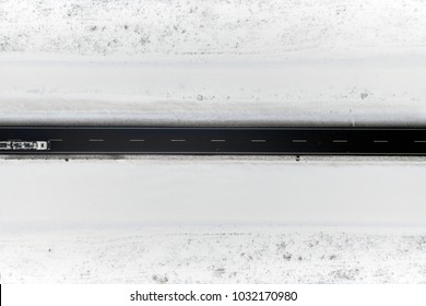 Aerial View Of Winter Road In Snowy Fields. Drone Captured Shot From Above.