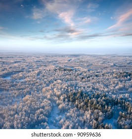 Aerial view of winter woodlands during a flight at frosty day.