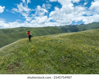 Aerial view of woman cyclist carrying a mountain bike climbing up to beautiful flowering grassland mountain top - Powered by Shutterstock