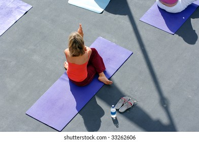 An Aerial View Of A Woman Exercising During An Outdoor Yoga Class