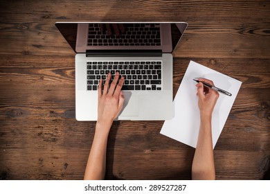 Aerial View Of Woman Typing On Laptop. Placed On Wooden Desk