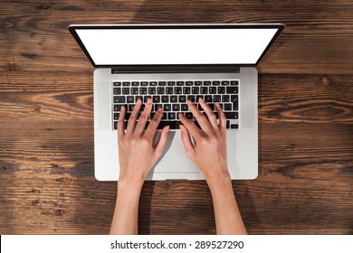 Aerial View Of Woman Typing On Laptop. Placed On Wooden Desk