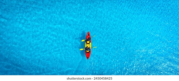 Aerial view of a woman and a young man kayaking on clear blue waters at Andaman Island. She does water sports activities. - Powered by Shutterstock