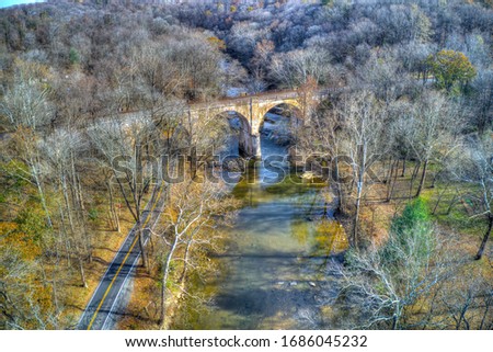 Aerial View of Woods in Fall Colors with a Road, Stream and Railroad Bridge
