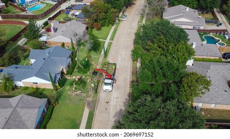 Aerial View Working Truck With A Lift Cutting Down Tree At Suburban House Near Dallas, Texas, America. Tree Pruning Landscaping Service At Residential Neighborhood.