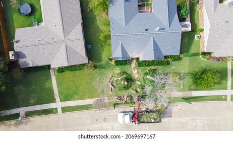 Aerial View Working Truck With A Lift Cutting Down Tree At Suburban House Near Dallas, Texas, America. Tree Pruning Landscaping Service At Residential Neighborhood.