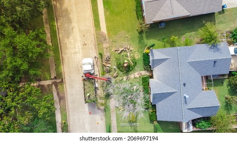 Aerial View Working Truck With A Lift Cutting Down Tree At Suburban House Near Dallas, Texas, America. Tree Pruning Landscaping Service At Residential Neighborhood.