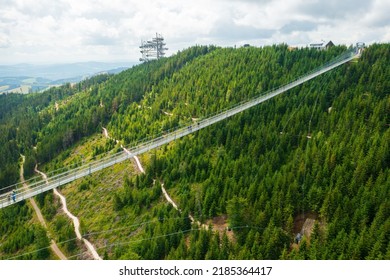 Aerial view of the worlds longest 721 meter suspension footbridge Sky bridge and observation tower the Sky walk in the forest, between mountains, Dolni Morava Ski Resort, Czech Republic.  - Shutterstock ID 2185364417