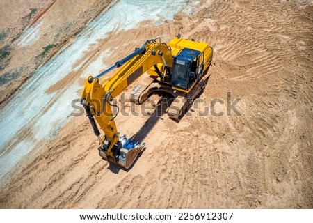 aerial view of an yellow excavator on the construction site