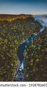 Aerial view of the Youghiogheny River as it cuts through the Laurel Highland mountains during sunrise in late summertime
