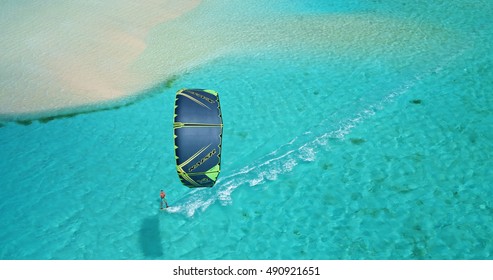 Aerial view young man kitesurfing in tropical blue ocean, extreme sport