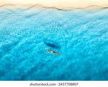 Aerial view of young woman lying on transparent canoe in blue sea at sunset. Summer in Zanzibar. Top drone view of beautiful slim girl, kanoe, sandy beach, ocean with clear water. Tropical background - Powered by Shutterstock