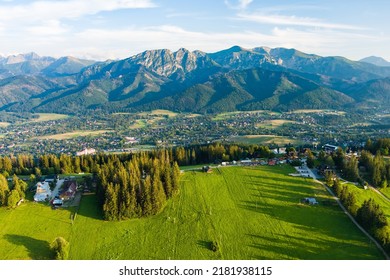 Aerial view of Zakopane town underneath Tatra Mountains taken from the Gubalowka mountain range. High mountains and green hills in summer or spring. Scenic mountain view in Poland. - Powered by Shutterstock