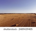 Aerial wide angle Square Hay Bales field with tractor Baler. Small agribusiness, state financial assistance to farmers