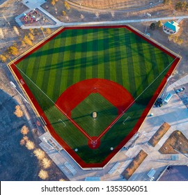 Aerial wide angle view of a green baseball field diamond in the morning sunlight.