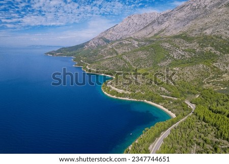 AERIAL: Winding road in breathtaking hilly landscape on coast of Adriatic Sea. Panoramic Adriatic highway with stunning views connecting cities and tourist destinations in coastal region of Croatia.