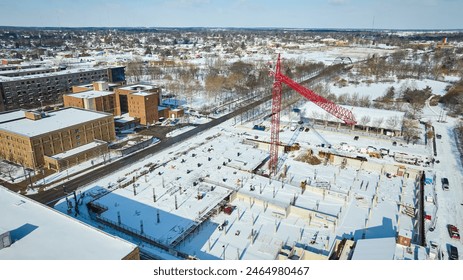 Aerial Winter Construction Scene with Red Crane in Snow-covered Urban Area - Powered by Shutterstock