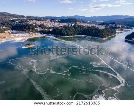 Aerial winter view of Dospat Reservoir covered with ice, Smolyan Region, Bulgaria