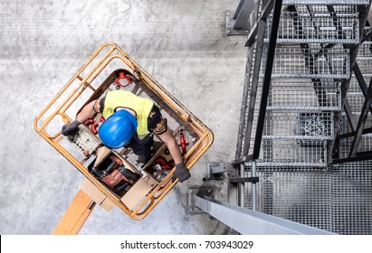 Aerial of a worker with blue hardhat on a cherry picker