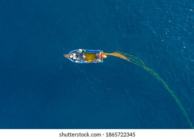 Aerial-Drone view fisherman catching fish using net at the ocean