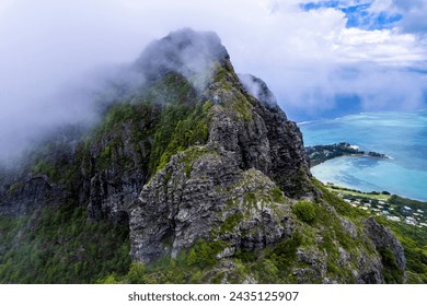 Aerialview of sky over top of mountain with fog and green jungle after raining in morning, Le Morne Brabant Mountain - Mauritius. Shot from drone.