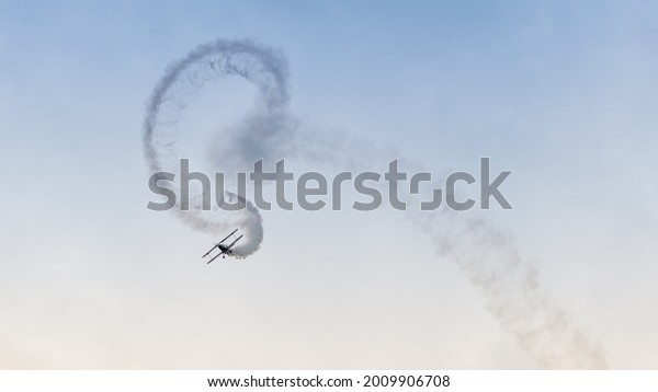 An\
aerobatic display of a vintage biplane with\
smoke